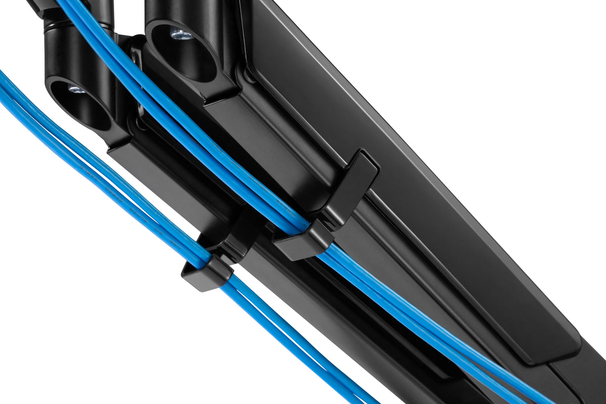 Close-up of the monitor arm cable channel with a blue cable routed through it