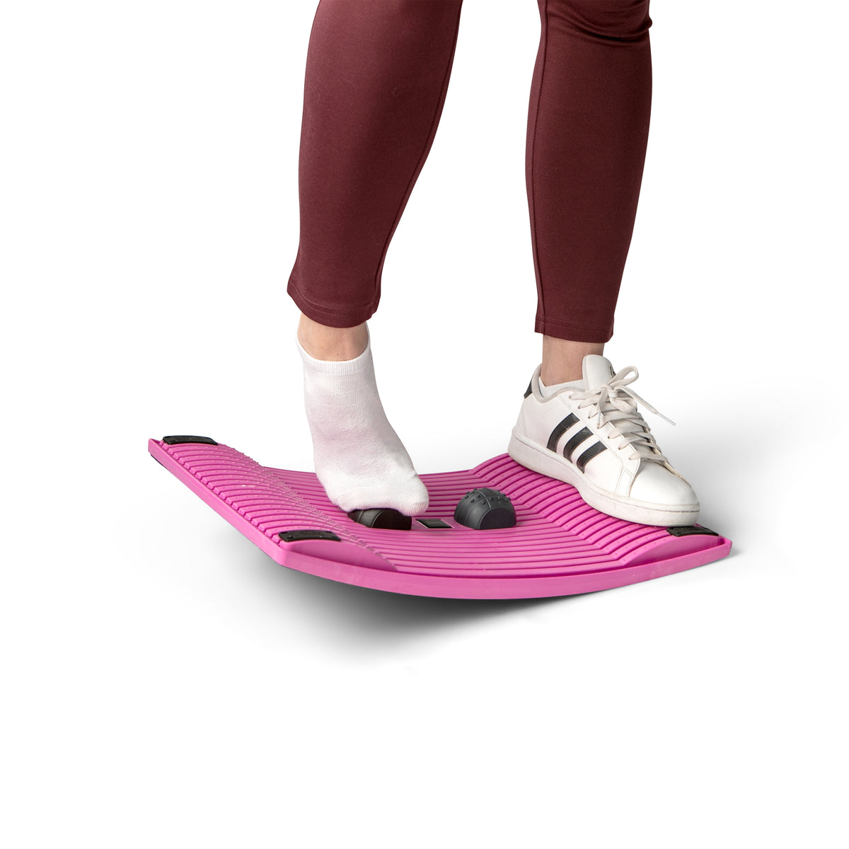 Person standing on a pink Gymba board, seen from the knees down