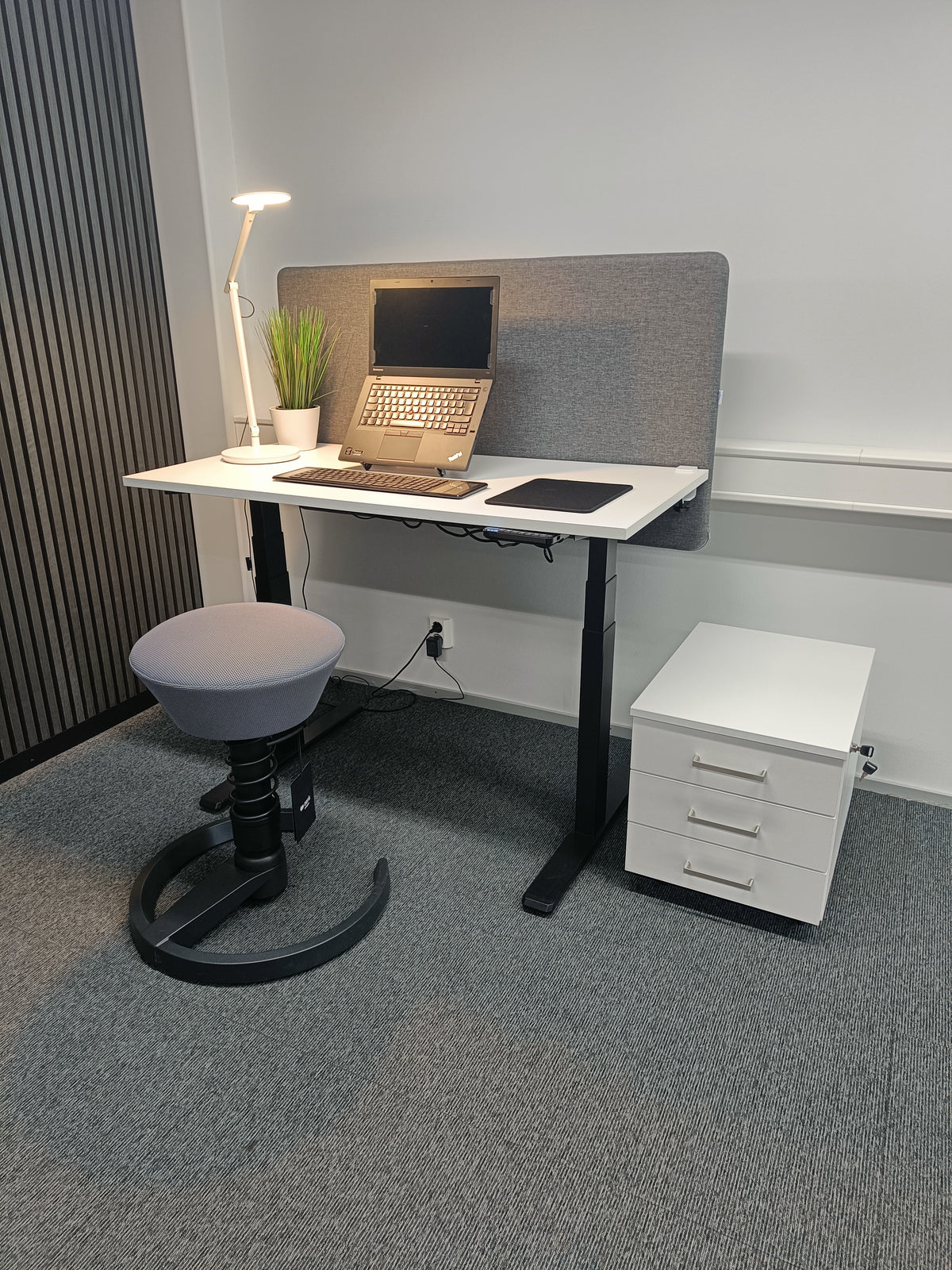 Office workstation with a white three-drawer pedestal beside the desk