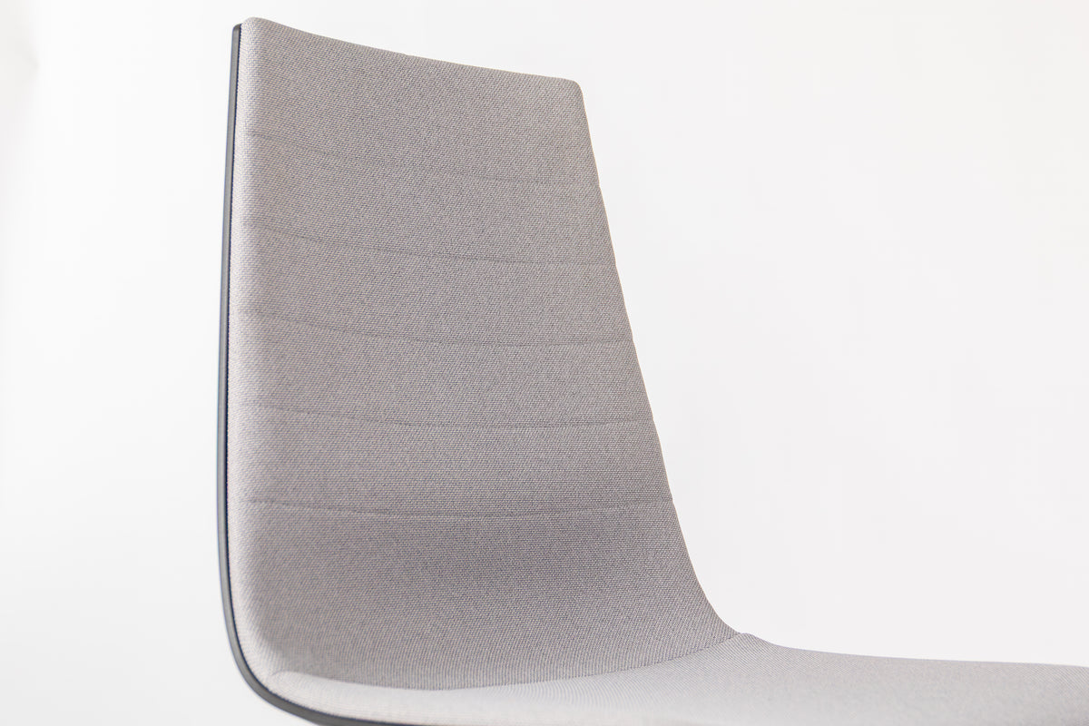 Close-up of the moulded backrest shell of a Linu Task chair in light grey