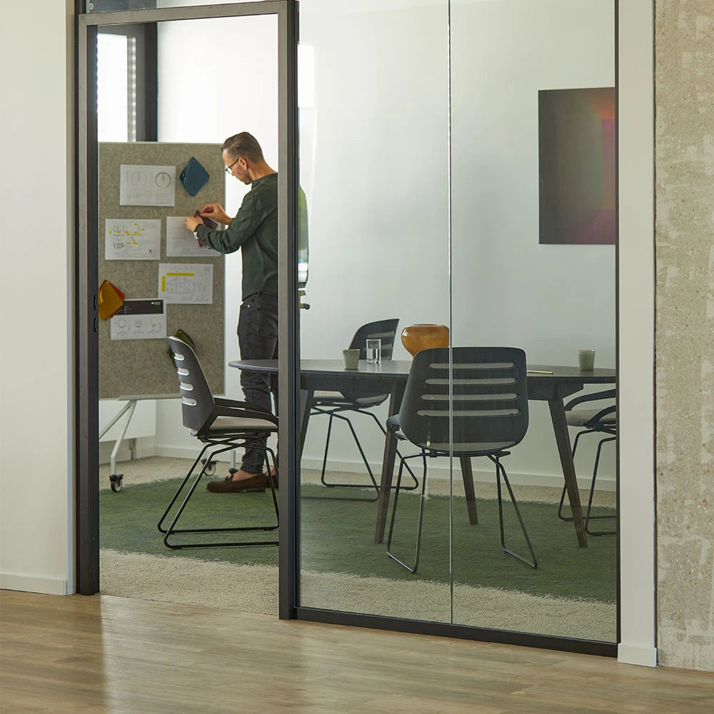 Numo Comfort chairs with skid bases around a table in a glass-walled meeting room