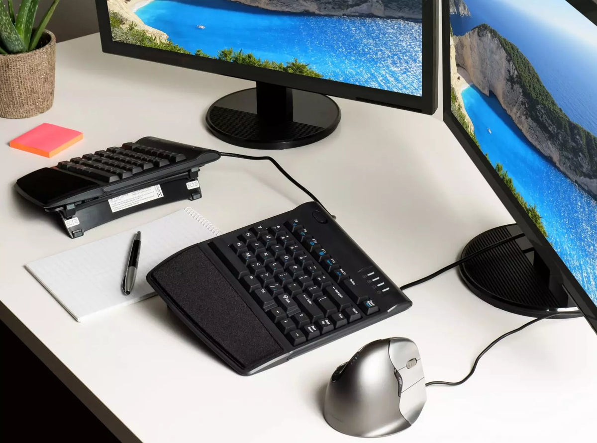 Desk with a Freestyle 2 keyboard tented on VIP3 brackets beside a monitor