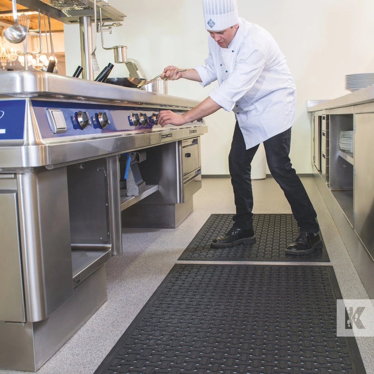 Chef standing on a nitrile workstation mat at a stainless steel counter