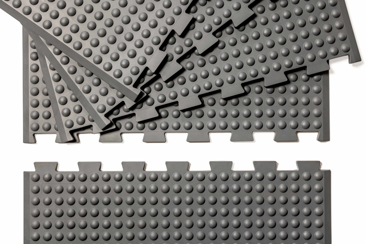 Grey GetUpMat Puzzle extension pieces for customizable standing mat, featuring interlocking design for easy width adjustment.