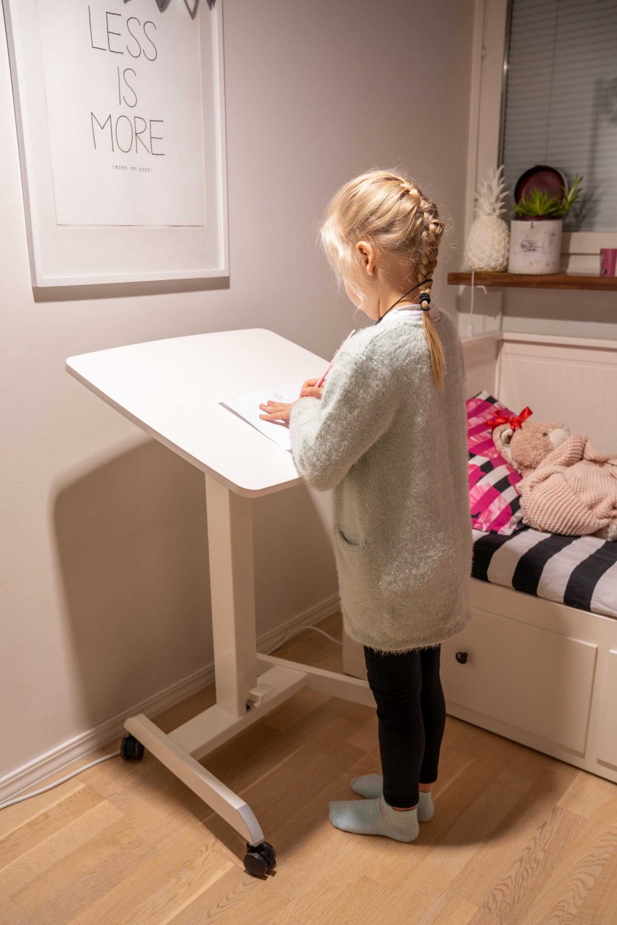 Woman standing at a GetUpDesk Tilt desk with the top tilted