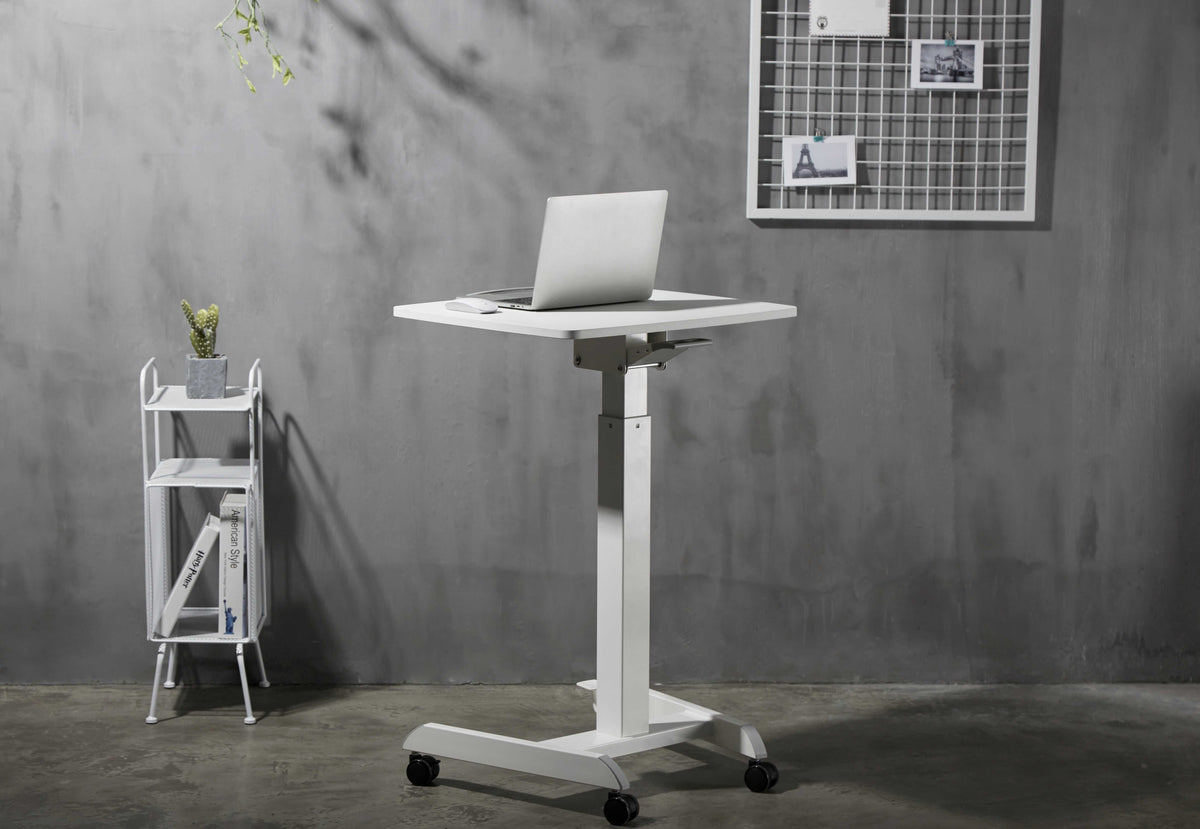 White GetUpDesk Tilt desk with a laptop against a concrete wall
