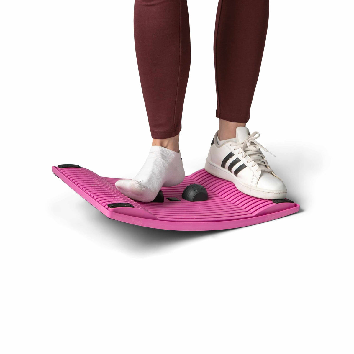 Person balancing on pink activation board for improved movement and circulation at work.