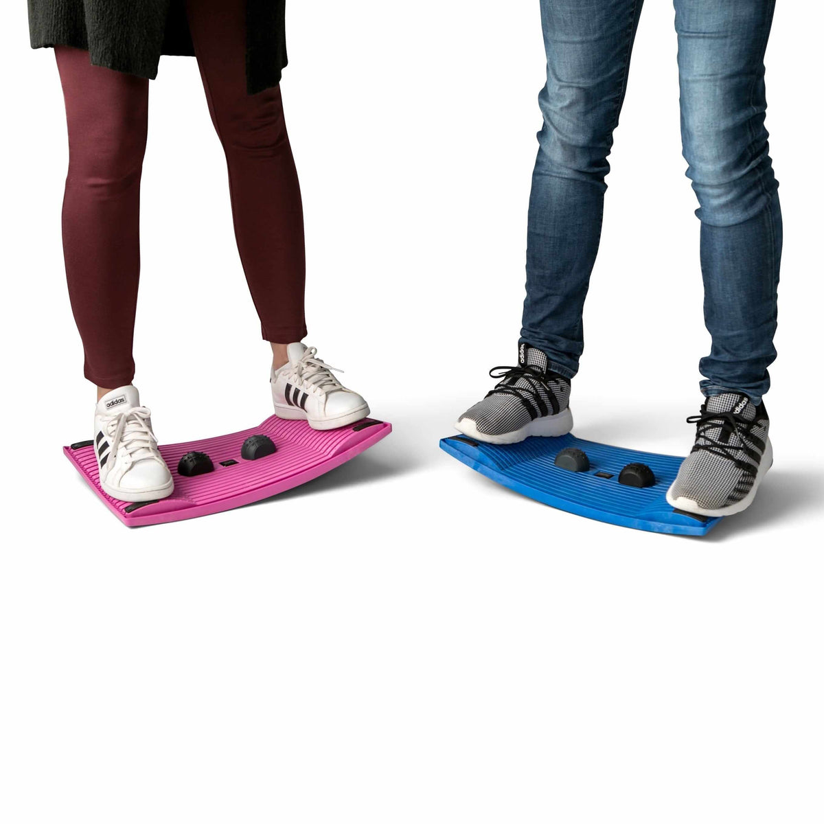 Two people using pink and blue Gymbailu activation boards for movement and balance.