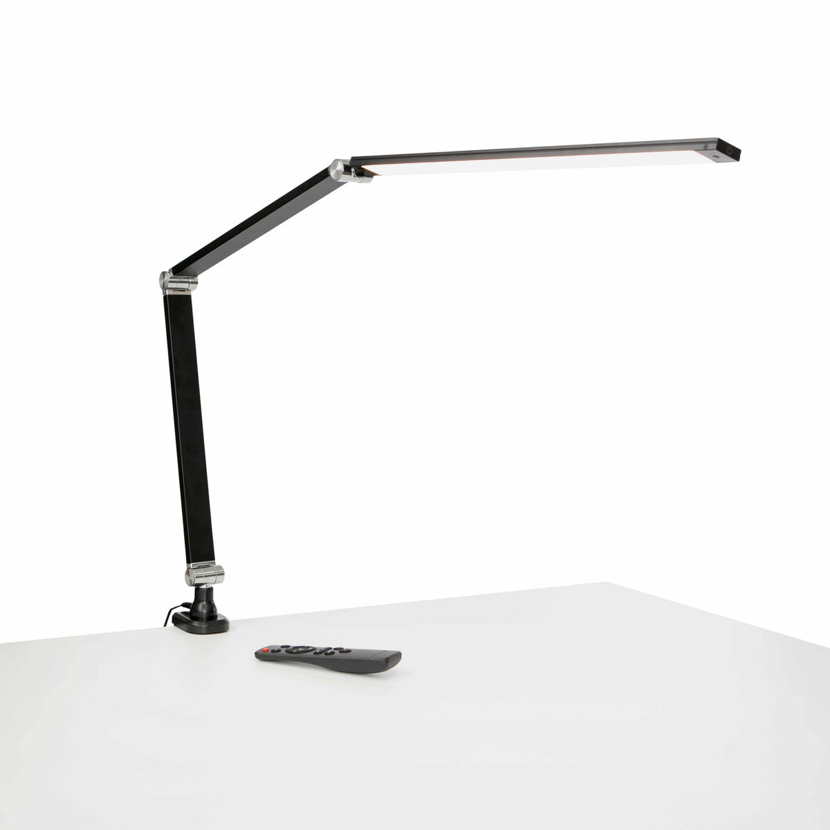 Black Link LED desk lamp with adjustable metal arm on a white desk.