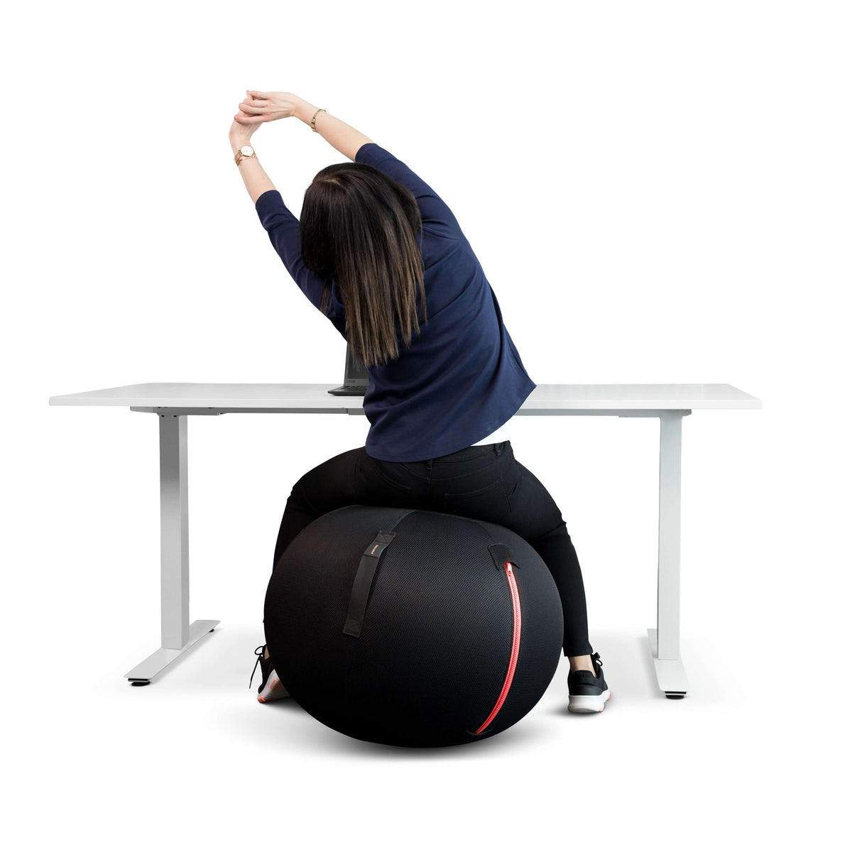 Woman stretching while seated on a GetUpBall office ball at a desk