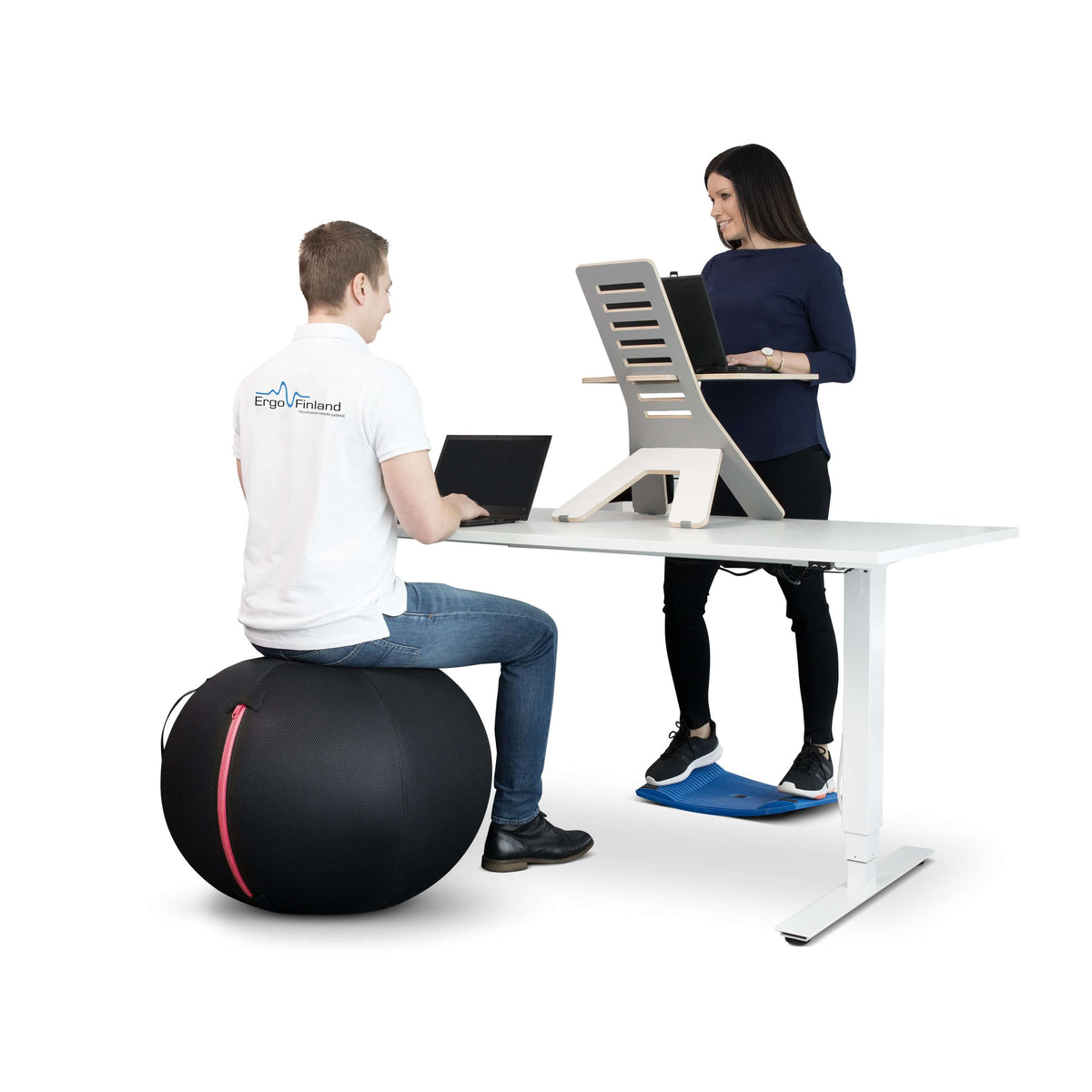 Two people working at desks, one seated on a GetUpBall office ball