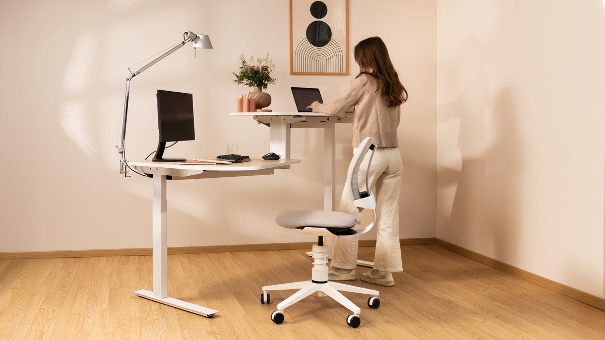 Person working at a white desk while seated on a white 3Dee active chair in a home office