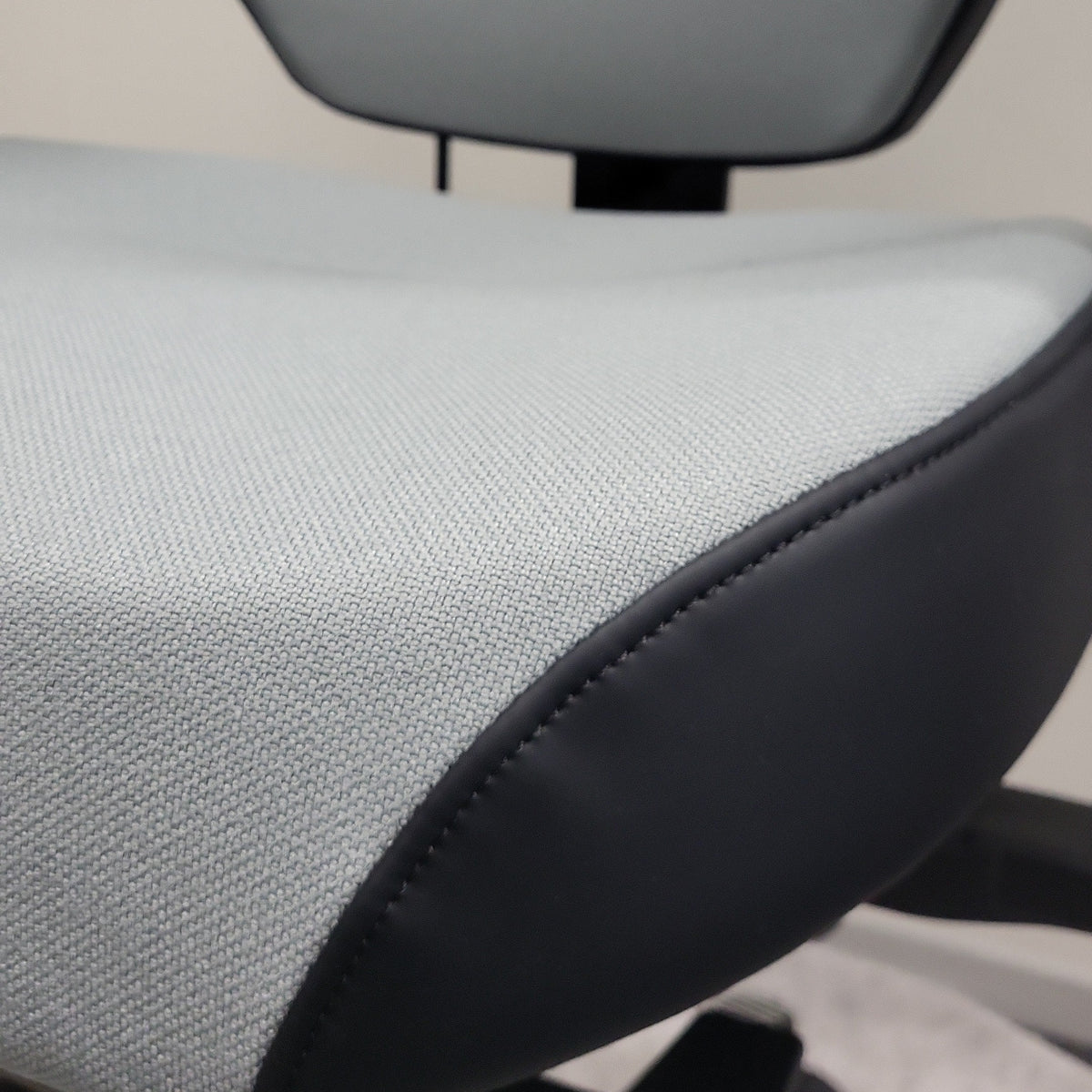 Close-up of the grey fabric upholstery and black trim on the Josefin office chair