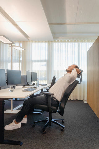 Man leaning back in an XXLis5 office chair beside an office window