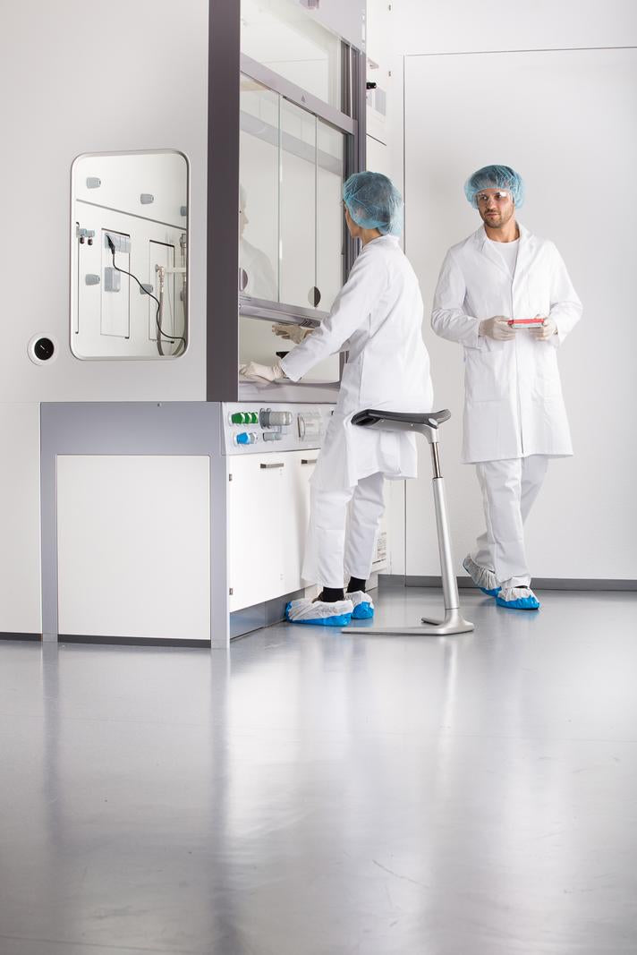 Two laboratory staff in a clean room with a FIN leaning chair at a workstation