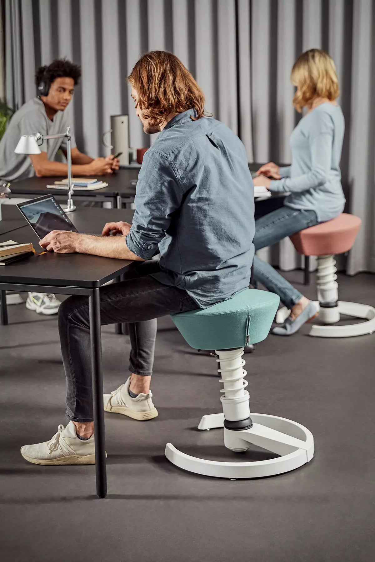 Colleagues working at a table on Swopper active chairs