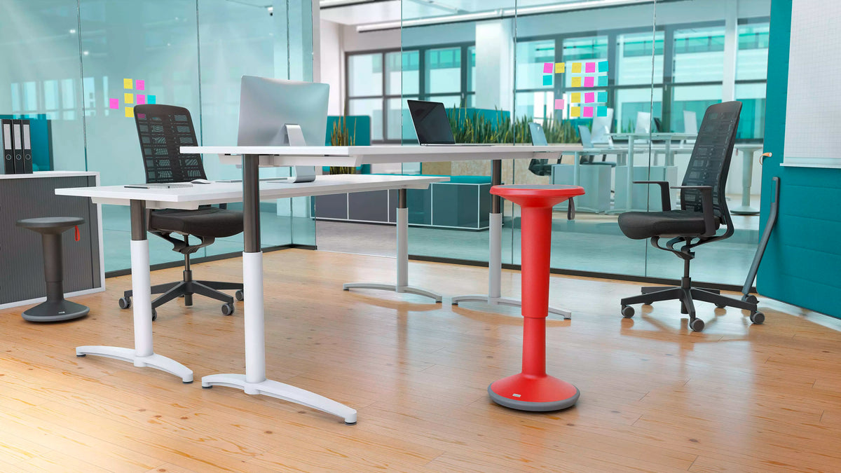 Office interior with a red UPis1 active chair at a standing desk