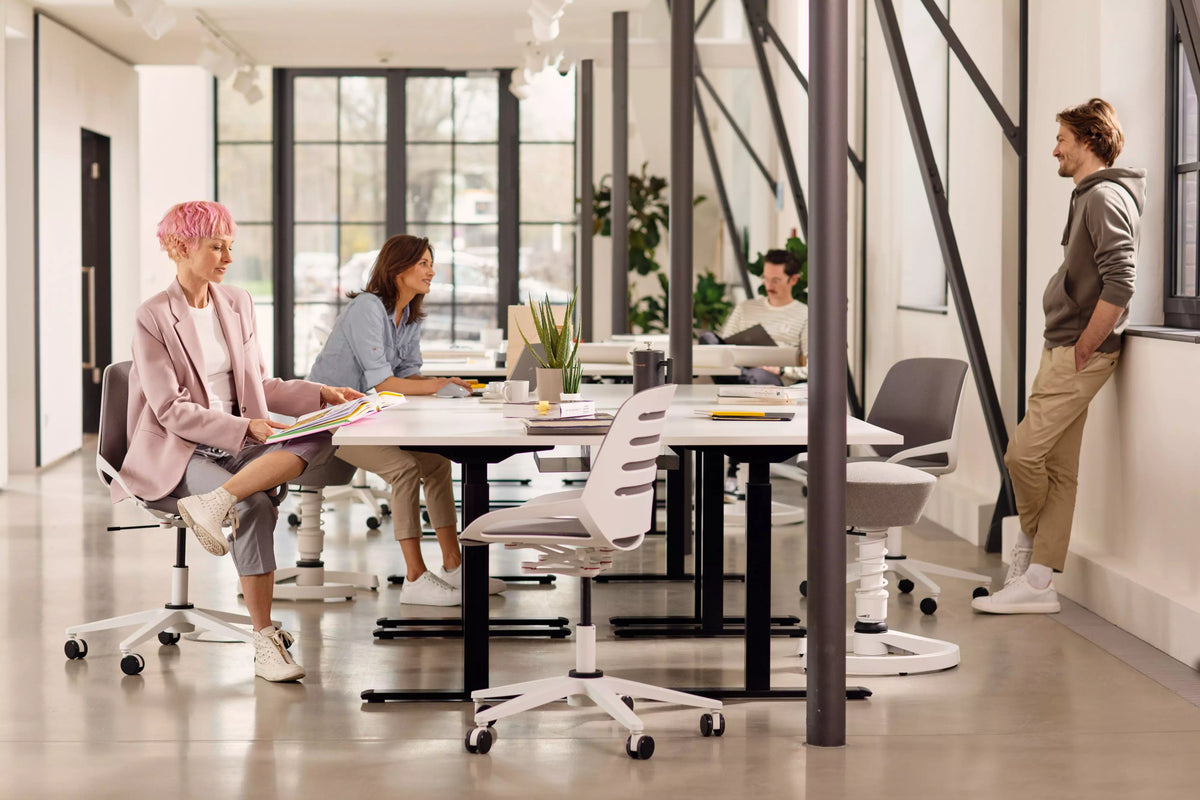 Colleagues meeting around a table on Numo Task active chairs