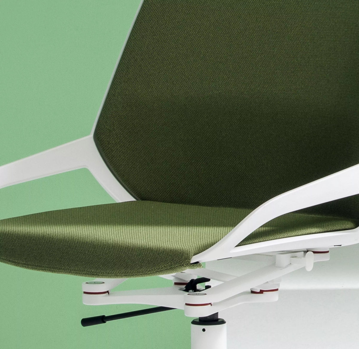 Close-up of the green upholstered seat and white shell of a Numo Task active chair