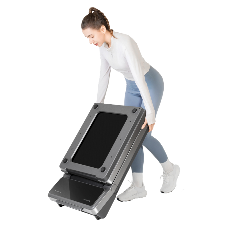 Woman wheeling a folded WalkingPad V2 treadmill across a room