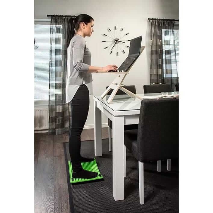 Woman working at a standing desk with a GetUpDesk Light stand and floor mat