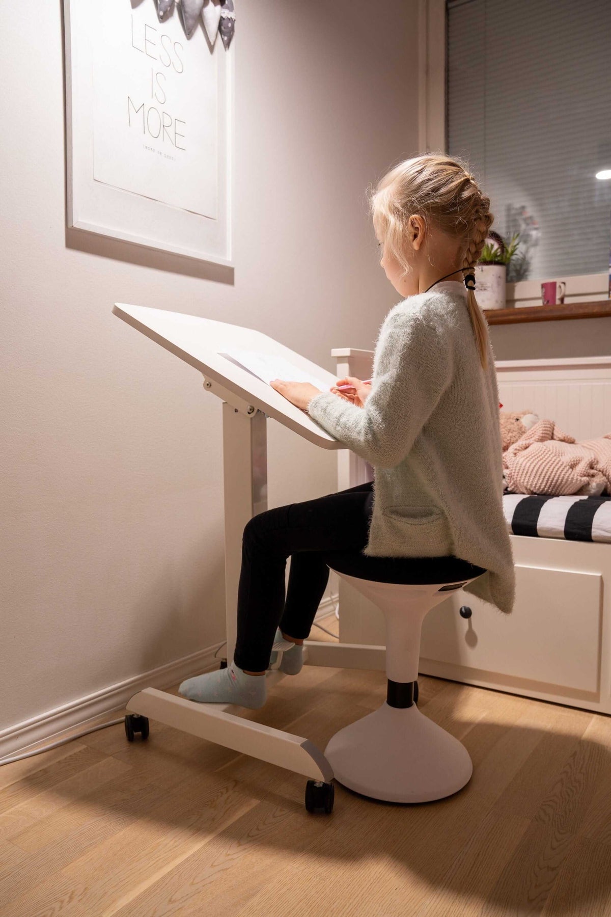 Woman working at a tilted GetUpDesk Tilt desk in a home room
