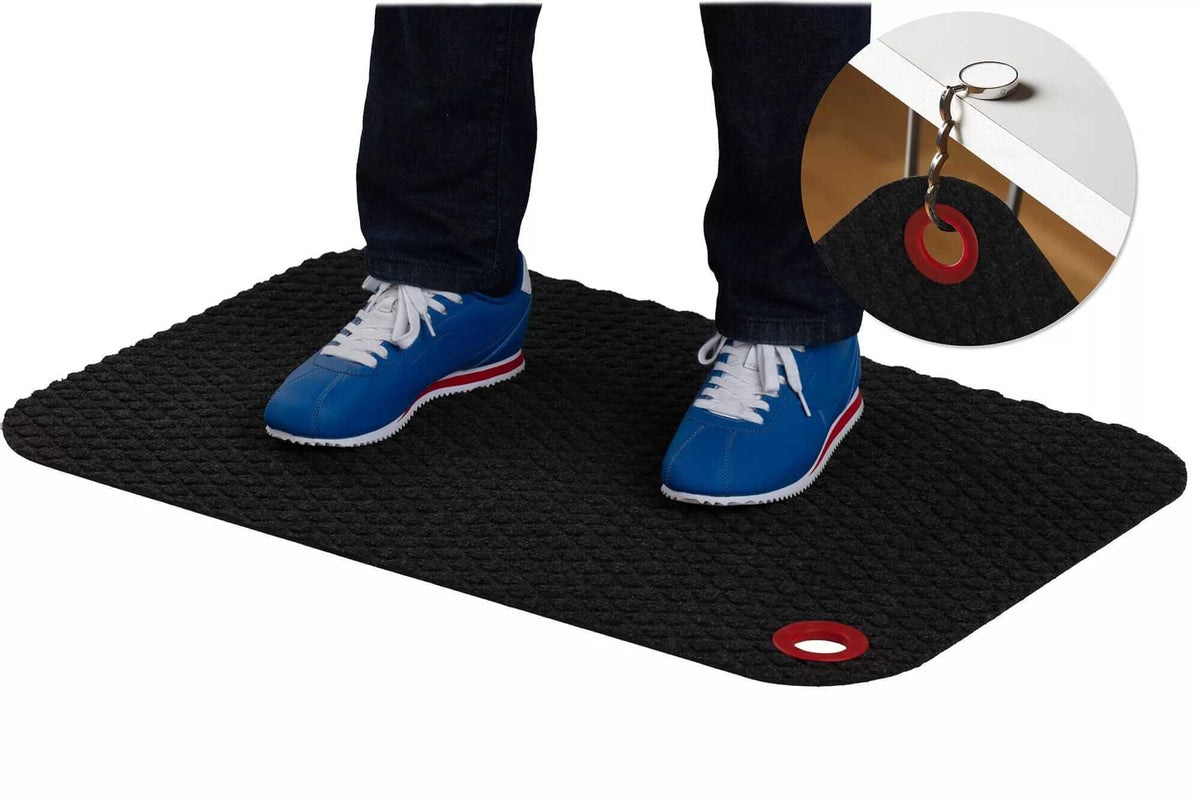 Person standing on StandMat Textile workstation mat with blue shoes, showcasing polypropylene surface and keyhole detail.